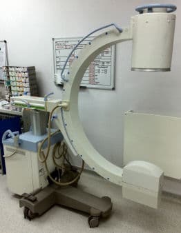 Mobile C-arm fluoroscopy X-ray unit on a wheeled base