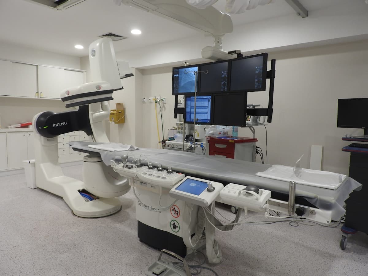 Cardiovascular cath lab imaging system with overhead C-arm and monitor array