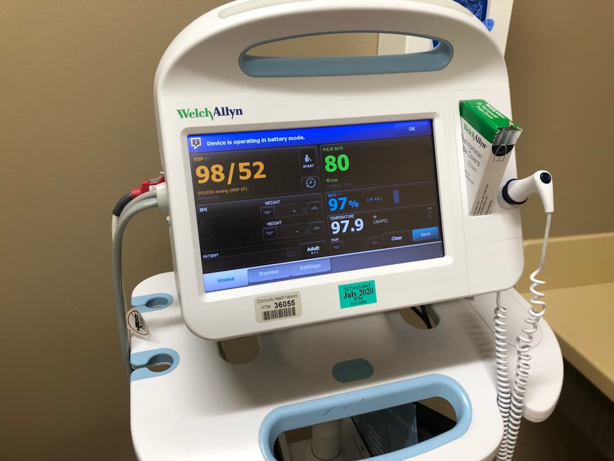Bedside patient vital signs monitor displaying blood pressure, pulse, and SpO2